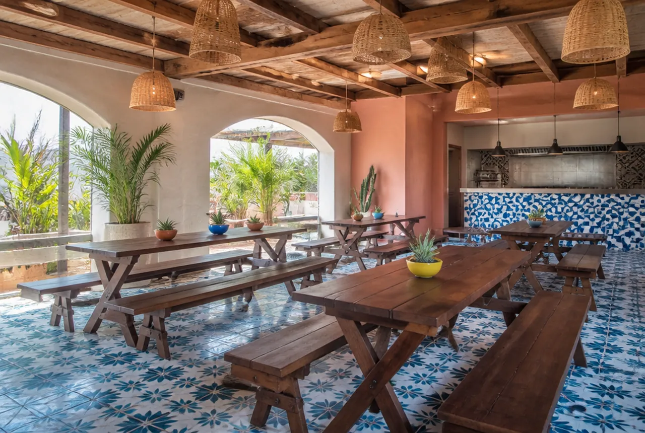 Taqueria dining room with tiled walls, an open service counter and closely spaced wipe down tables